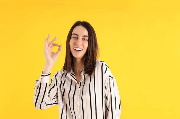 Young attractive girl in shirt on yellow background - Photo, Image