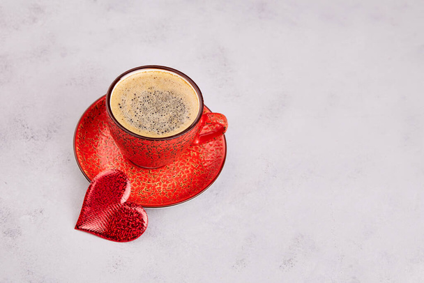 Red coffee cup, heart decoration on a gray background. Greeting card for Valentine's Day. The concept of minimalism. Copy space - Foto, immagini