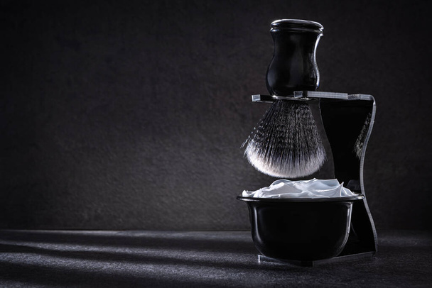 Бритье пены в чаше для бритья и бритье дерзость в стенде комплект на темном фоне - Фото, изображение