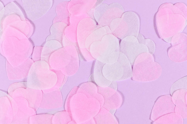 Pastel pink and white heart shaped paper confetti on violet background - Foto, Imagem