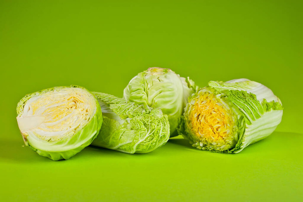 Peking cabbage on a green background. Cabbage close up. Copy space and place for text near greenery. - Photo, Image