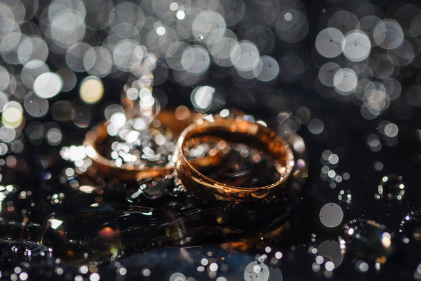 Trouwringen met waterdruppels, De verlovingsring set., Prachtige zilveren achtergrond met trouwringen en sterren - Foto, afbeelding
