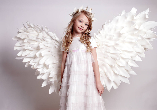 Pretty young lady with angel wings.Isolated studio shot - Фото, изображение