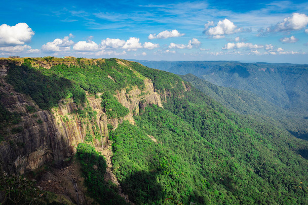 mountain range covered with green forests and bright blue sky at afternoon from flat angle image is taken at seven sister waterfall cherrapunji meghalaya india. - Фото, зображення