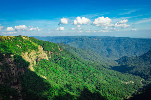 pohoří pokryté zelenými lesy a jasně modrá obloha v odpoledních hodinách z plochého úhlu obraz je pořízen na sedm sestra vodopád cherrapunji meghalaya indie. - Fotografie, Obrázek