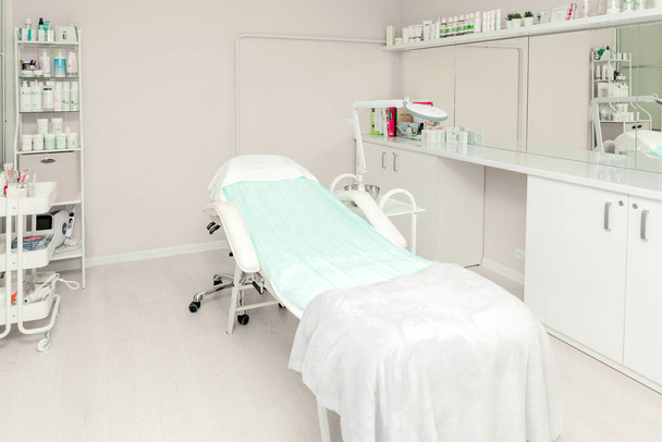 Cosmetologist empty office with care cosmetics and massage table in a modern beauty salon. Medical cabinet interior. Modernized cosmetic center for health care - Minsk, Belarus- August 20, 2021 - Foto, afbeelding