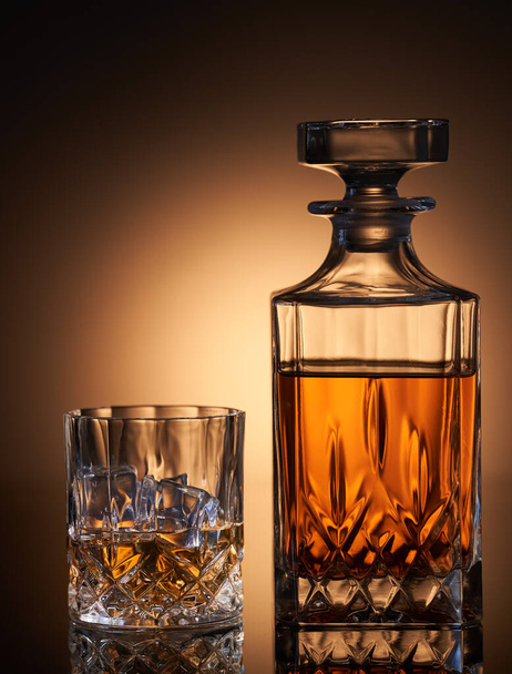 Scotch whiskey with ice in a glass and a bottle - Фото, изображение
