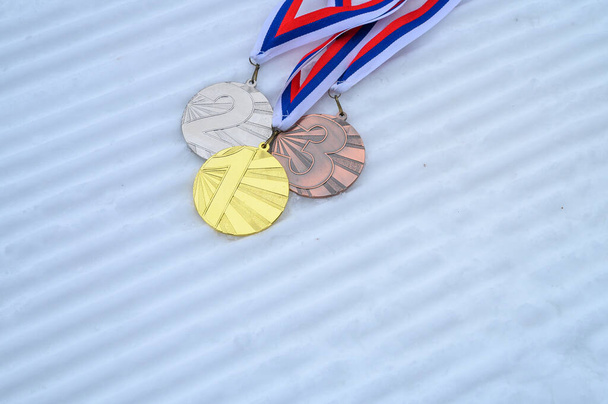 Gold, silver and bronze medal with winter nature in background. Sport trophy concept photo for winter game in China - Foto, imagen