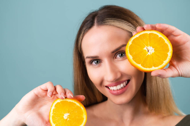 Close-up retrato de mulher topless com pele perfeita e maquiagem natural, lábios nus completos, segurando fresco citrinos vitamina C laranja - Foto, Imagem