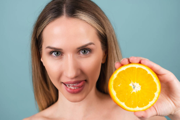 Portret topless kobiety z idealną cerą i naturalnym makijażem, pełne nagie usta, trzymając świeże cytrusy witamina C pomarańczowy - Zdjęcie, obraz