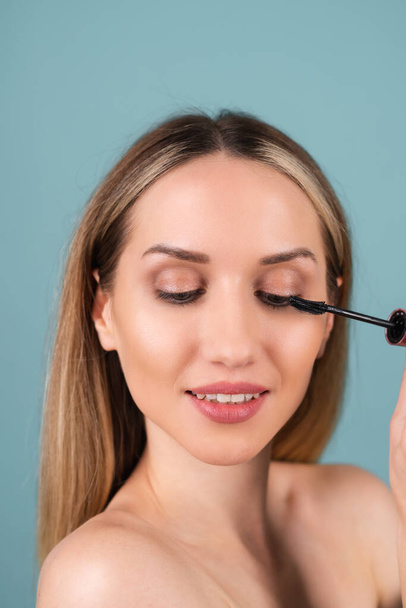 Close-up portrait of topless woman with perfect skin and natural make-up, nude lips, holding mascara wand - Photo, Image