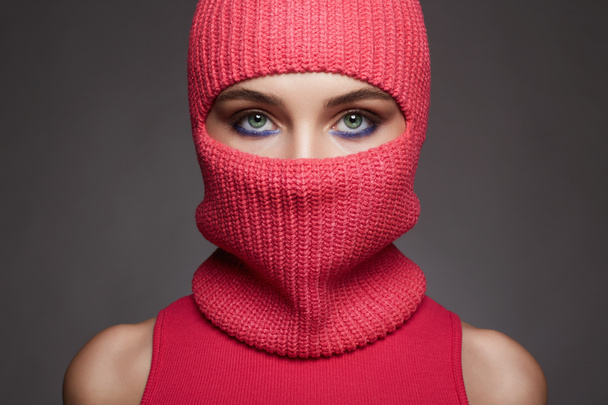 beautiful eyes of girl in red balaclava. New Hat style. Trendy Mask on pretty woman - Photo, image