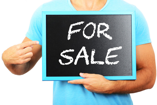 άνθρωπος κρατώντας μαυροπίνακα στα χέρια και δείχνοντας τη λέξη προς πώληση - Φωτογραφία, εικόνα