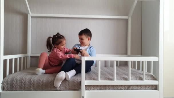 "Μικρό κορίτσι κάθεται σε ένα κρεβάτι Montessori και παίζει με ένα παιχνίδι τούβλα κύβο.Κρεβάτι για παιδιά σε σχήμα σπιτιού" - Πλάνα, βίντεο