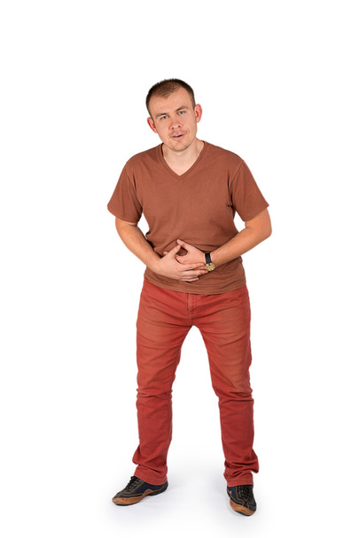 Молодий чоловік тримає руки на животі з болем
 - Фото, зображення