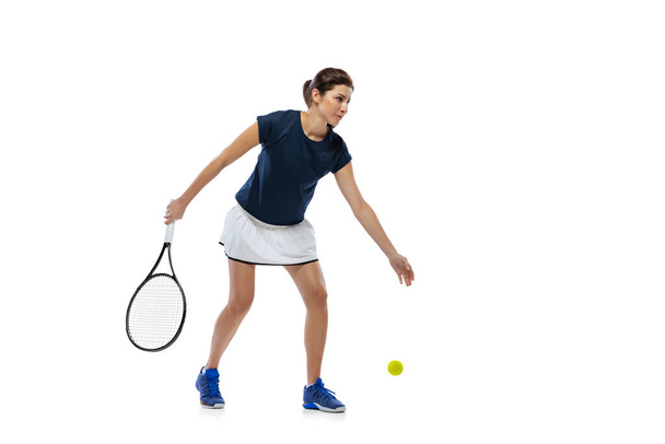 Portret van jonge sportieve vrouw, tennisser spelen tennis geïsoleerd op witte achtergrond. Gezonde levensstijl, fitness, sport, trainingsconcept. - Foto, afbeelding