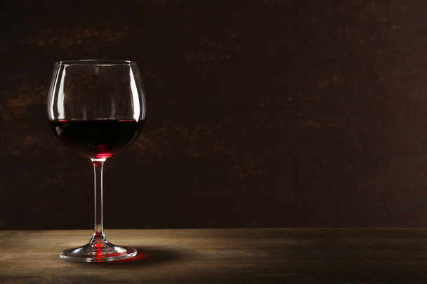 Goblet of red wine on wooden table on wooden wall background - Valokuva, kuva