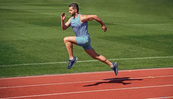 sportsman runner outdoor. health care. energy. muscular guy run to success. man running on stadium. sports and healthy lifestyle routine. sport workout. male athlete do morning exercise - 写真・画像