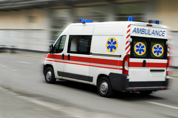 An ambulance is driving down the street - Φωτογραφία, εικόνα