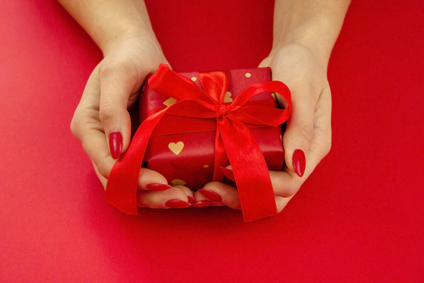 valentine. dárek v rukou na červeném pozadí. selektivní zaměření - Fotografie, Obrázek