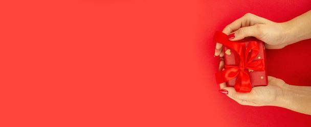 валентинка. подарунок в руках на червоному тлі. вибірковий фокус
 - Фото, зображення