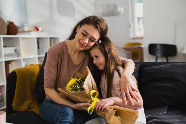 daughter gives a bouquet of flowers to her mother - Fotoğraf, Görsel