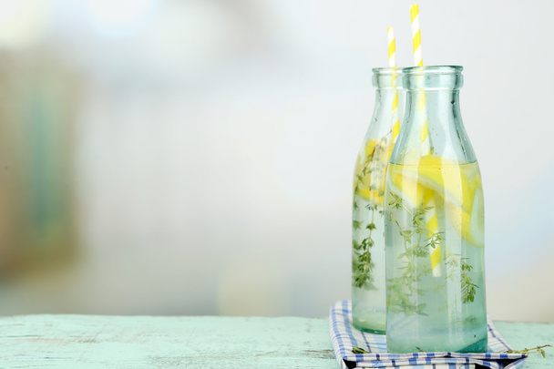 Tasty cool beverage with lemon and thyme, on light background - Photo, image