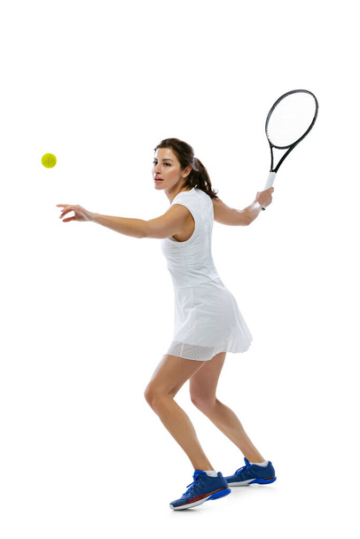 Dynamic portrait of young sportive woman, tennis player practicing isolated on white background. Healthy lifestyle, fitness, sport, exercise concept. - Фото, зображення