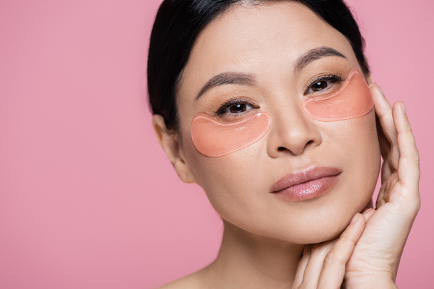 Portrait of asian woman with hydrogel eye patches isolated on pink  - Fotografie, Obrázek