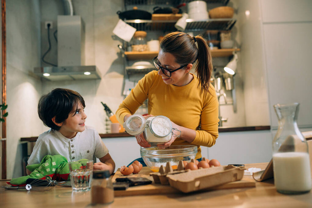 mother and her son preparing food in kitchen - Fotó, kép