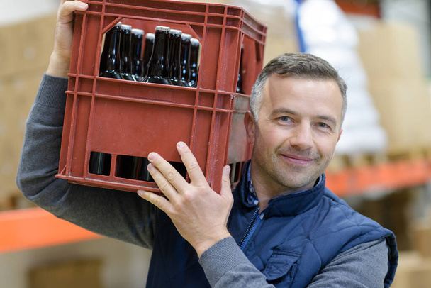 portrait of man carrying crate of beer - Fotoğraf, Görsel