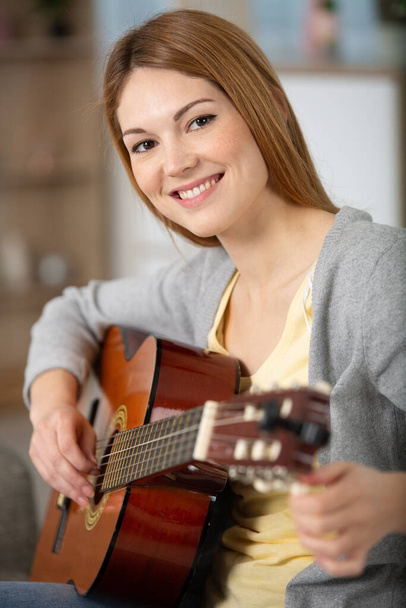 a beautiful woman smile while playing acoustic guitar - Foto, Imagem