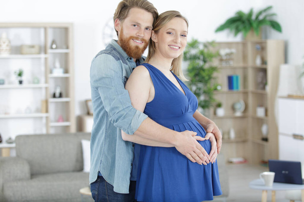 smiling pregnant young couple hugging - Foto, immagini