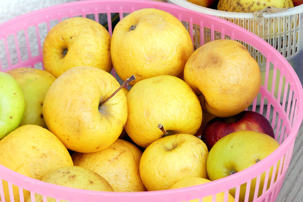 gele appels waarvan de sappen laag worden door de zon, appels beginnen te rotten in een kom, - Foto, afbeelding