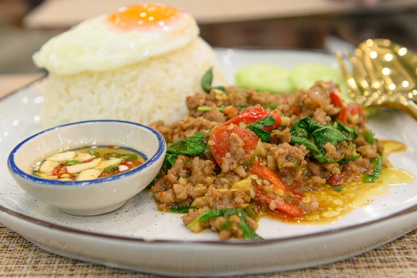 Mescolare il basilico tailandese fritto con carne di maiale macinata e un uovo fritto su riso condito - Foto, immagini