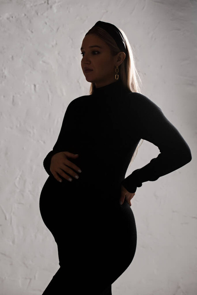 Portrait of a young beautiful pregnant woman in a black dress - Fotografie, Obrázek