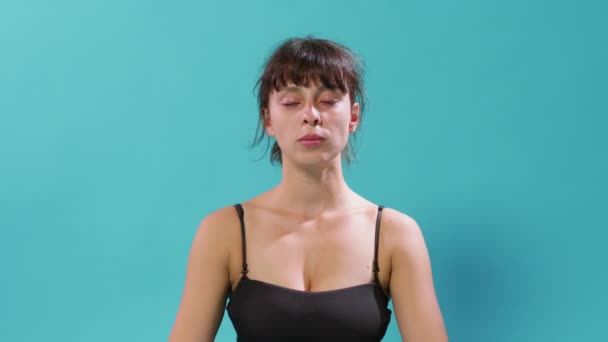 Porträt einer Frau, die mit geschlossenen Augen sitzt und tief atmet - Filmmaterial, Video