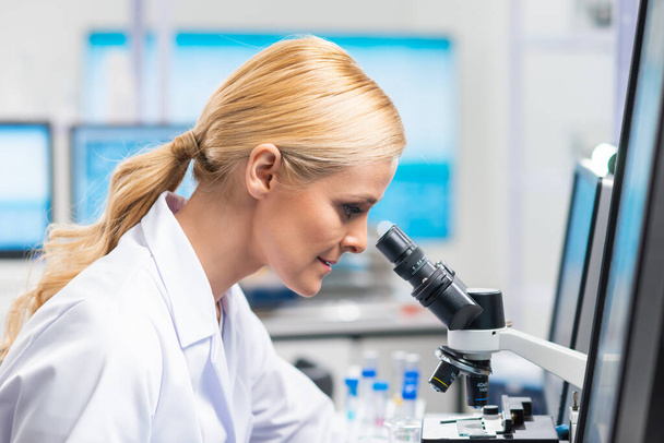 Professional female scientist is working on a vaccine in a modern scientific research laboratory. Genetic engineer workplace. Future technology and science. - Photo, image