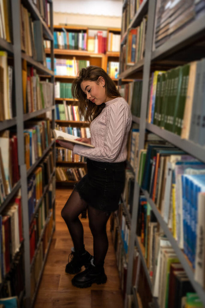 beautiful cute young girl reads and studies in the local library. Library concept. Reading concept - Valokuva, kuva