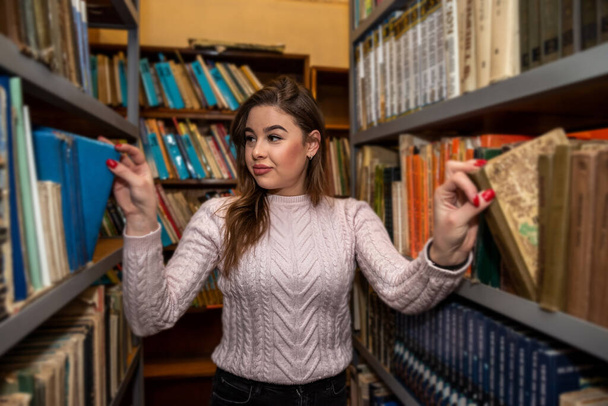Okuldan sonra şehir kütüphanesinde okuyan güzel bir genç kız. Kütüphane konsepti - Fotoğraf, Görsel