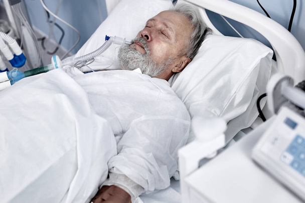 caucasian senior man patient lying on bed at hospital ward. Lonely old man - Photo, Image