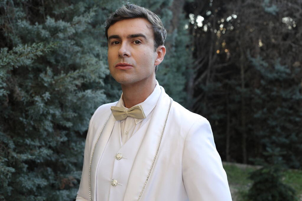 Nahaufnahme Porträt eines hübschen jungen Mannes im eleganten weißen Anzug im Freien - Foto, Bild