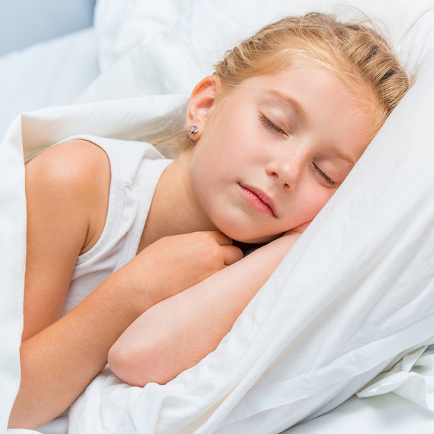 pieni tyttö nukkuu valkoisessa sängyssä
 - Valokuva, kuva