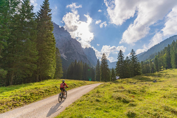 gyönyörű aktív idős nő elektromos mountain bike a látványos hegyekben Raintal Valley, oldalvölgy Lechtal, Tirol, Ausztria - Fotó, kép