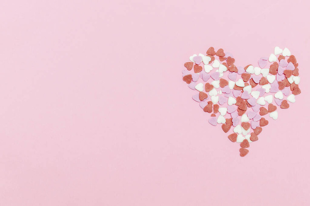 багато різнокольорових червоно-білих і рожевих зморшок у формі серця, солодкий конфетті, копіюють простір знущання. рожевий фон на день Святого Валентина, жіночий день, романтика, кольоровий простір копіювання кольору
. - Фото, зображення