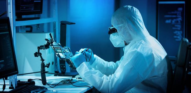 The scientist works in a modern scientific laboratory for the research and development of microelectronics and processors. Microprocessor manufacturing worker uses computer technology and equipment. - Foto, imagen