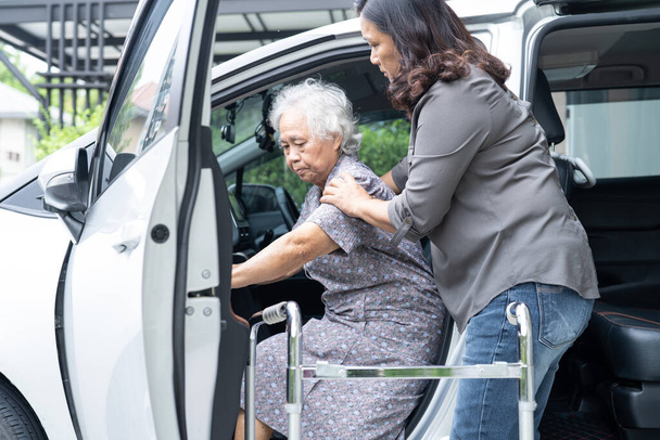 ヘルプとサポートアジアの高齢者の女性高齢者の女性患者歩くとともにウォーカー準備彼女の車に取得,健康的な強い医療の概念. - 写真・画像
