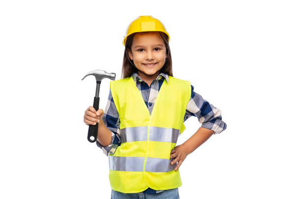 little girl in helmet and safety vest with hammer - Фото, изображение