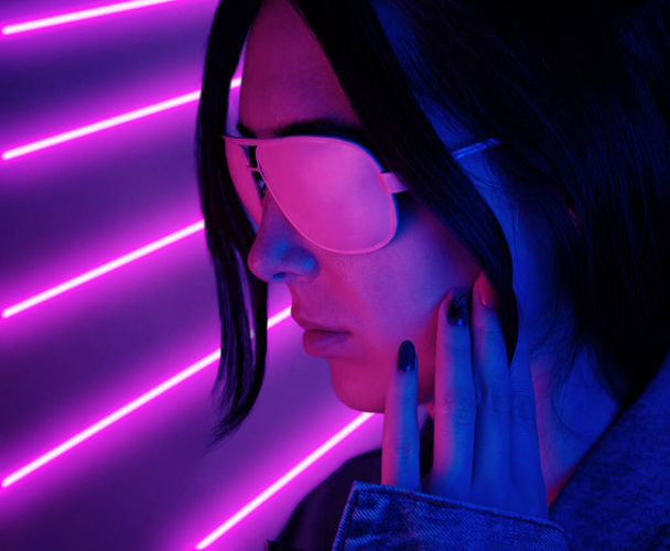 Portrait of a young beautiful woman in pink glasses in neon pink light. - Photo, image