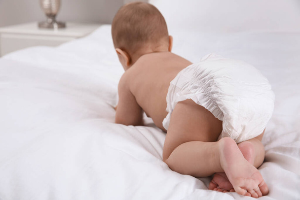 Cute baby in dry soft diaper on white bed, back view. Space for text - Fotografie, Obrázek